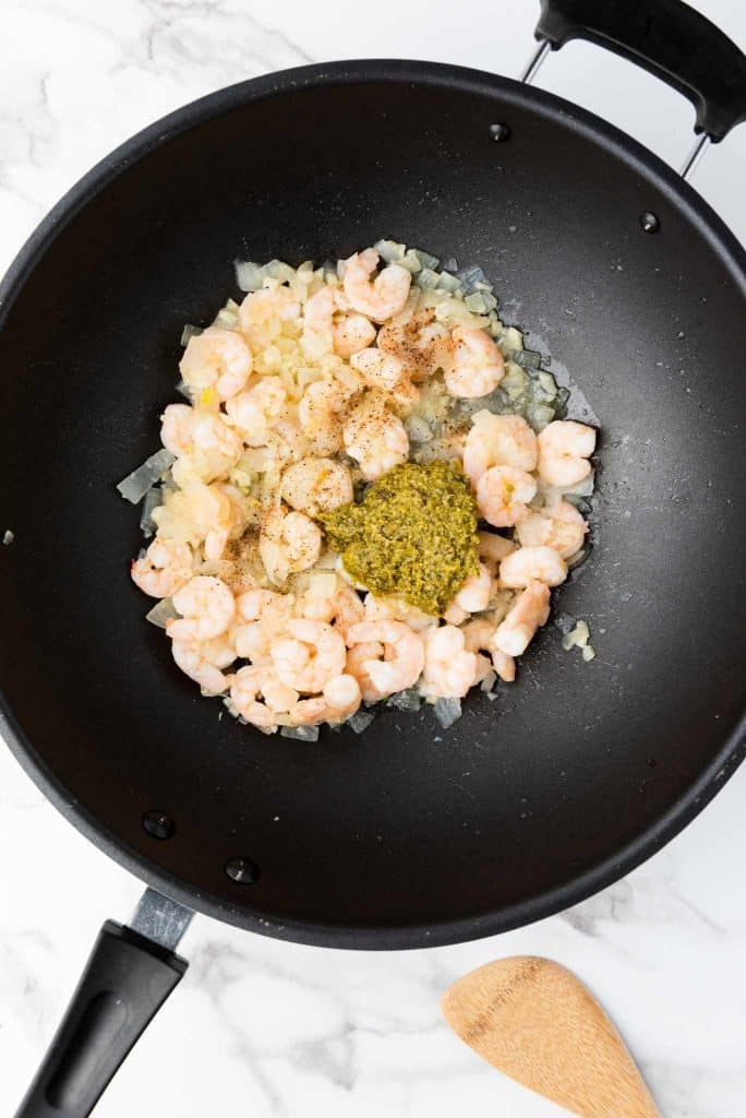 Peeled shrimp seasoned with salt and pepper in a pan.