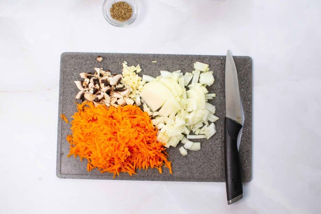 Cut onion into small cubes and grate the carrot in a chopping board.