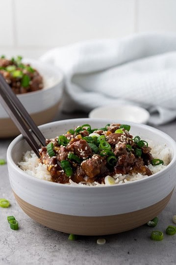 Slow cooker Mongolian Beef in a bowl with chopstick.