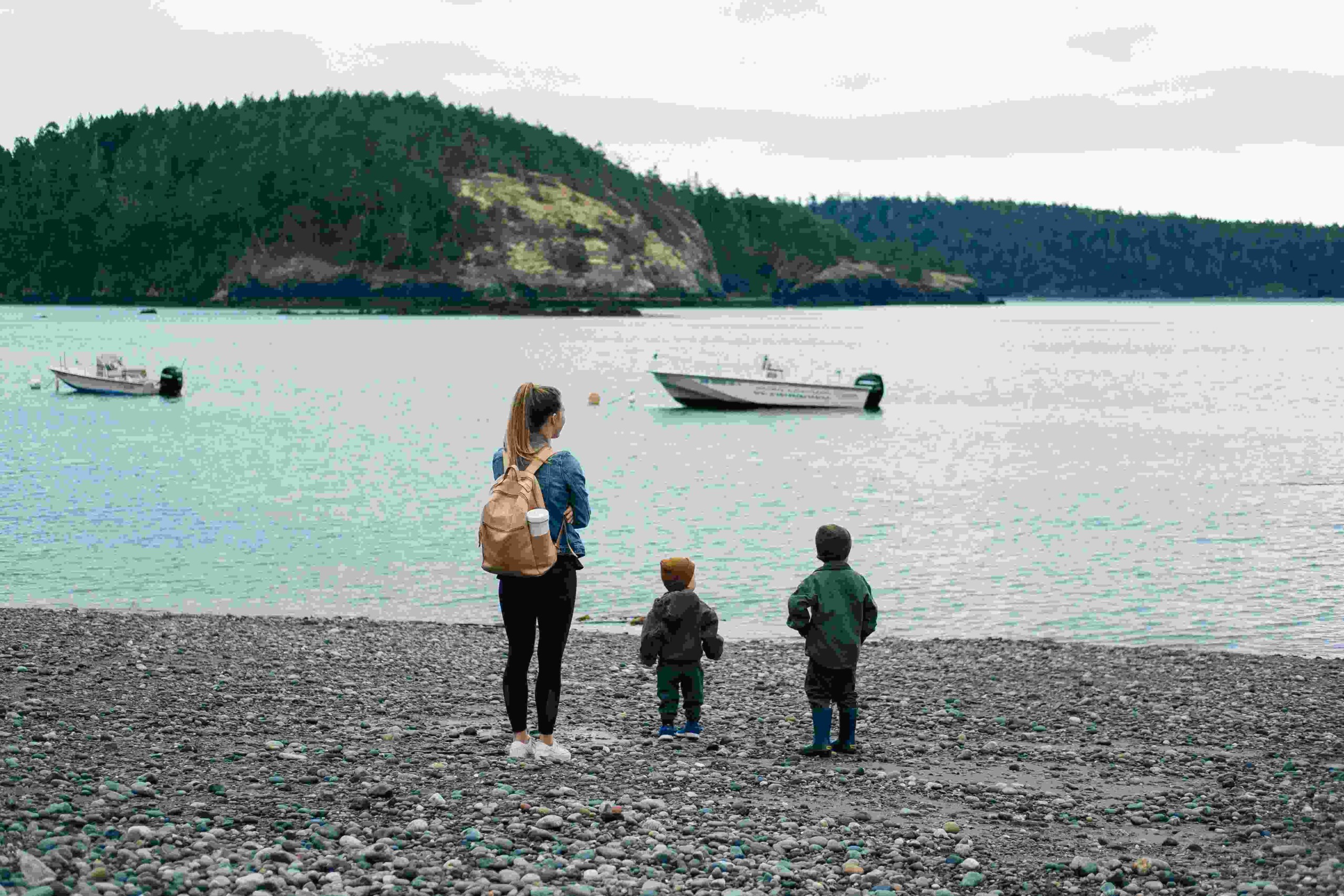 A mother and two children on the lake beach.