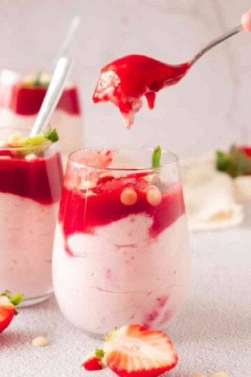 A person holding spoon for strawberry mascarpone mousse.