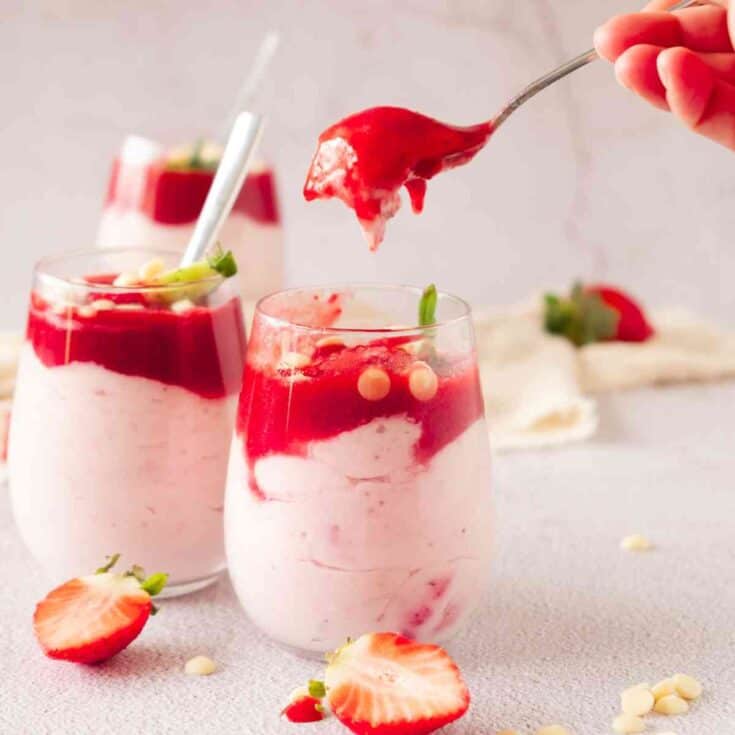 A person holding spoon for strawberry mascarpone mousse.
