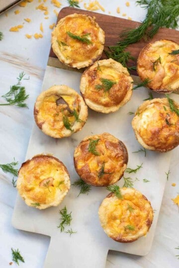 Served mini salmon quiches garnished with chopped dill.