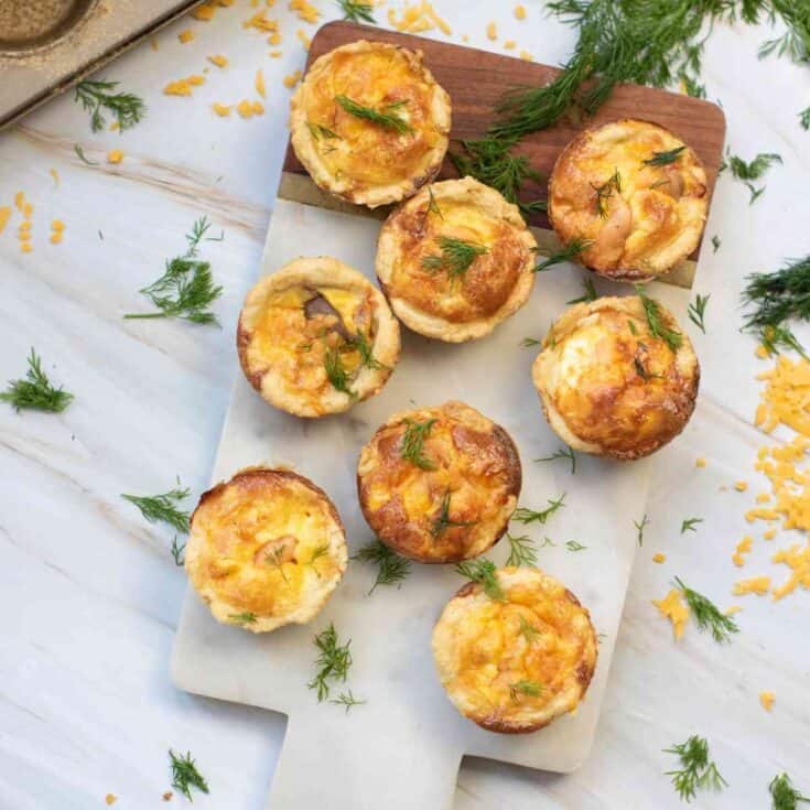 Served mini salmon quiches garnished with chopped dill.