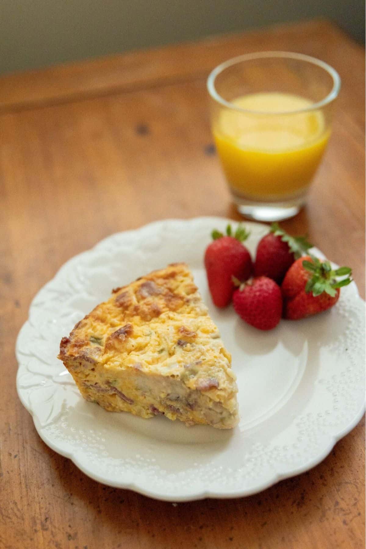 Sliced pie in a plate with fresh strawberries and glass of juice on the side.