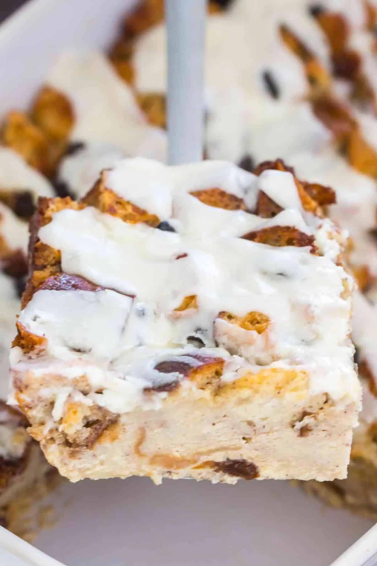 Close up photo of bread budding topped with creamy white filling.
