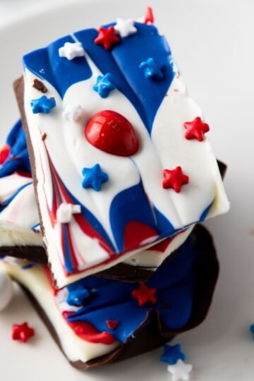 Close-up of a festive piece of chocolate bark decorated with red, white, and blue candy and sprinkles.