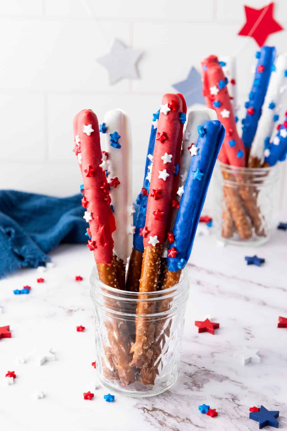 Red, white, and blue firecracker pretzel rods with sprinkles.