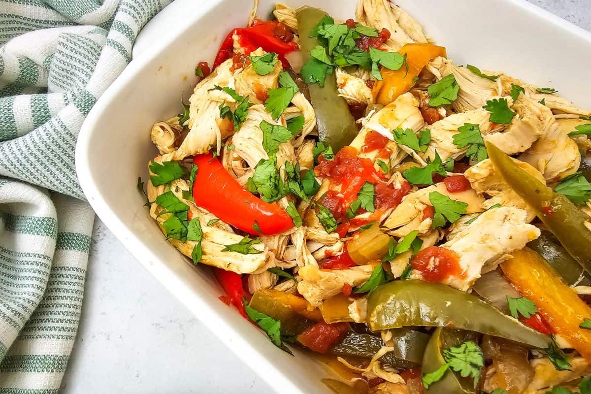 A serving dish with chicken fajitas, ready to be enjoyed with tortillas.