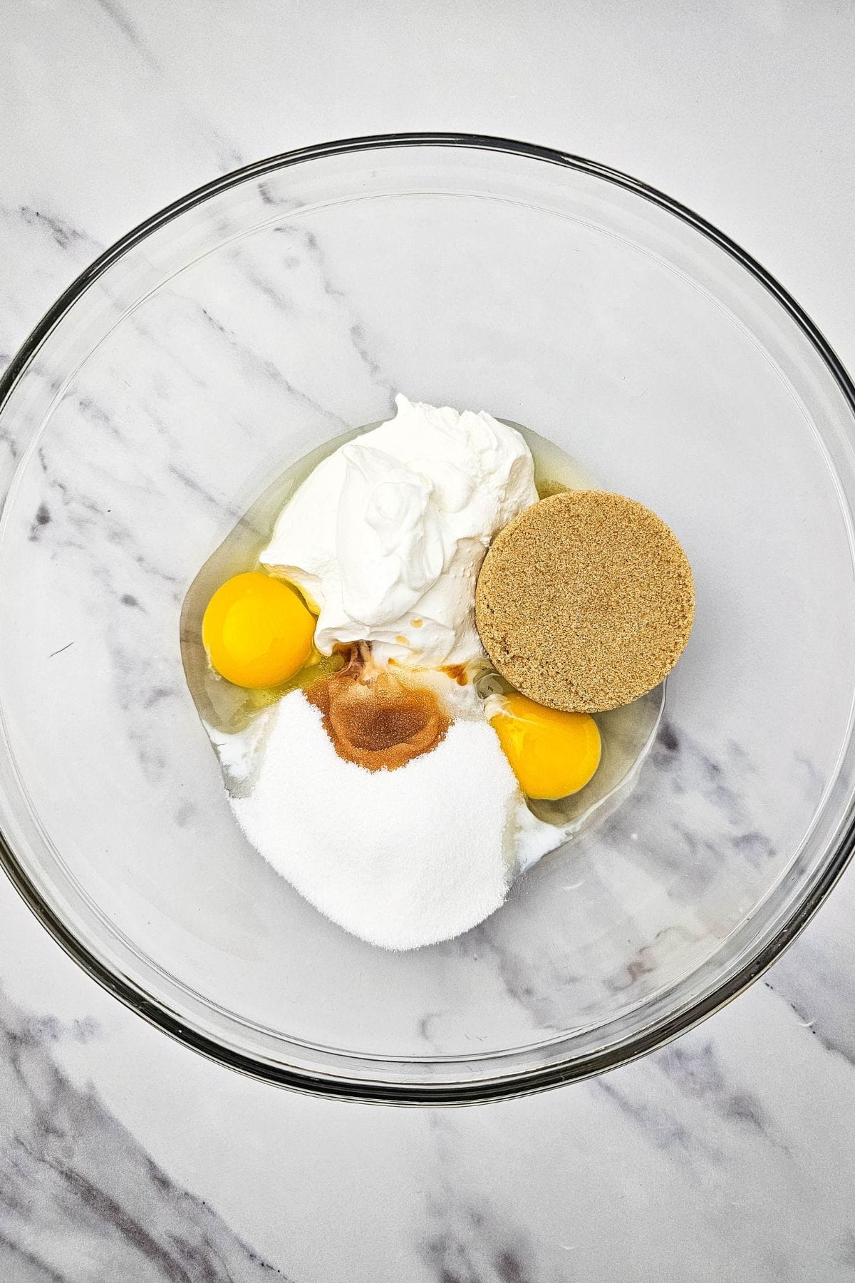 A mixing bowl containing ingredients for muffin batter, ready to combine.
