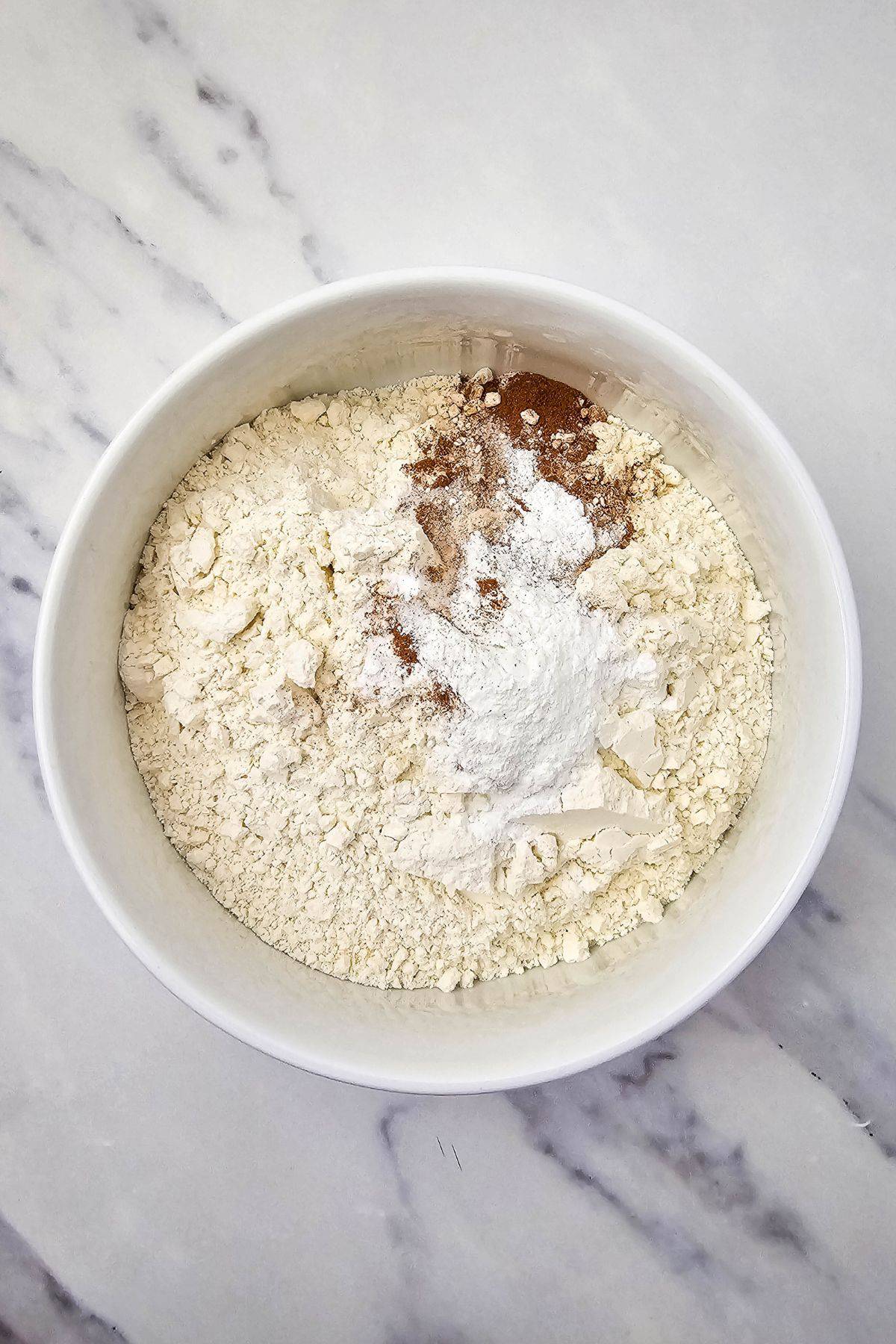 A mixing bowl containing ingredients for muffin batter, ready to combine.