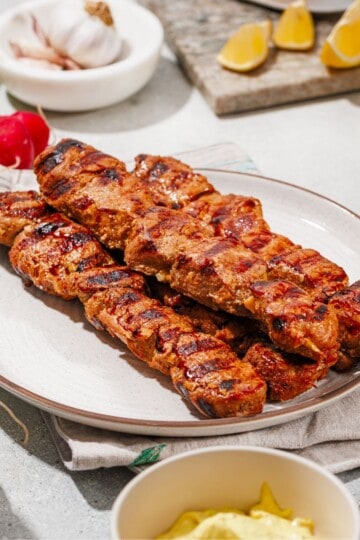 Grilled marinated pork skewers arr.anged on a plate