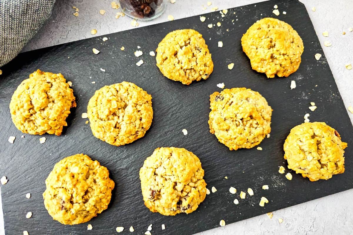 Freshly baked oatmeal raisin cookies with applesauce on a cooling rack.