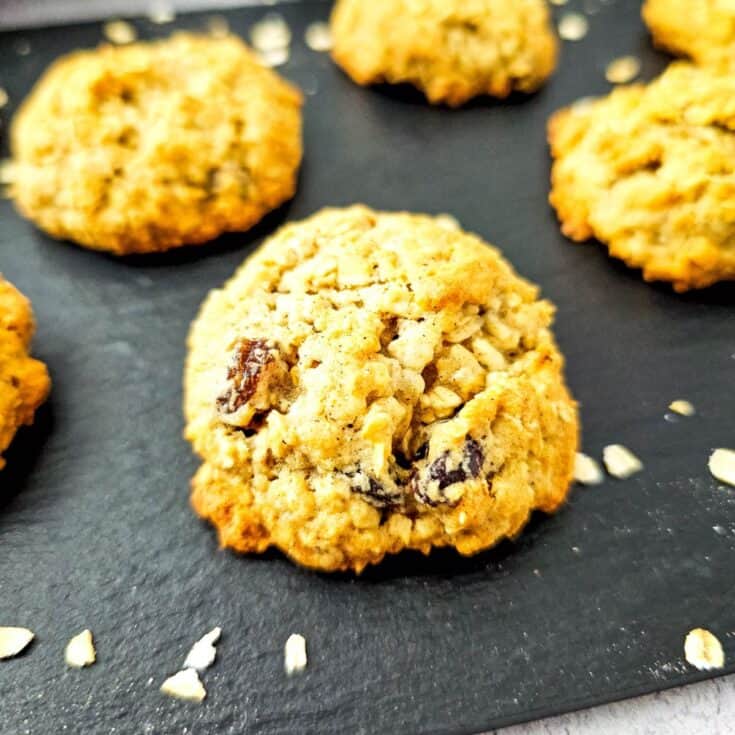 Freshly baked oatmeal raisin cookies with applesauce on a cooling rack.