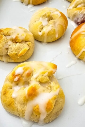 Golden brown cherry pie bites drizzled with a light sugar glaze, served warm and crispy.