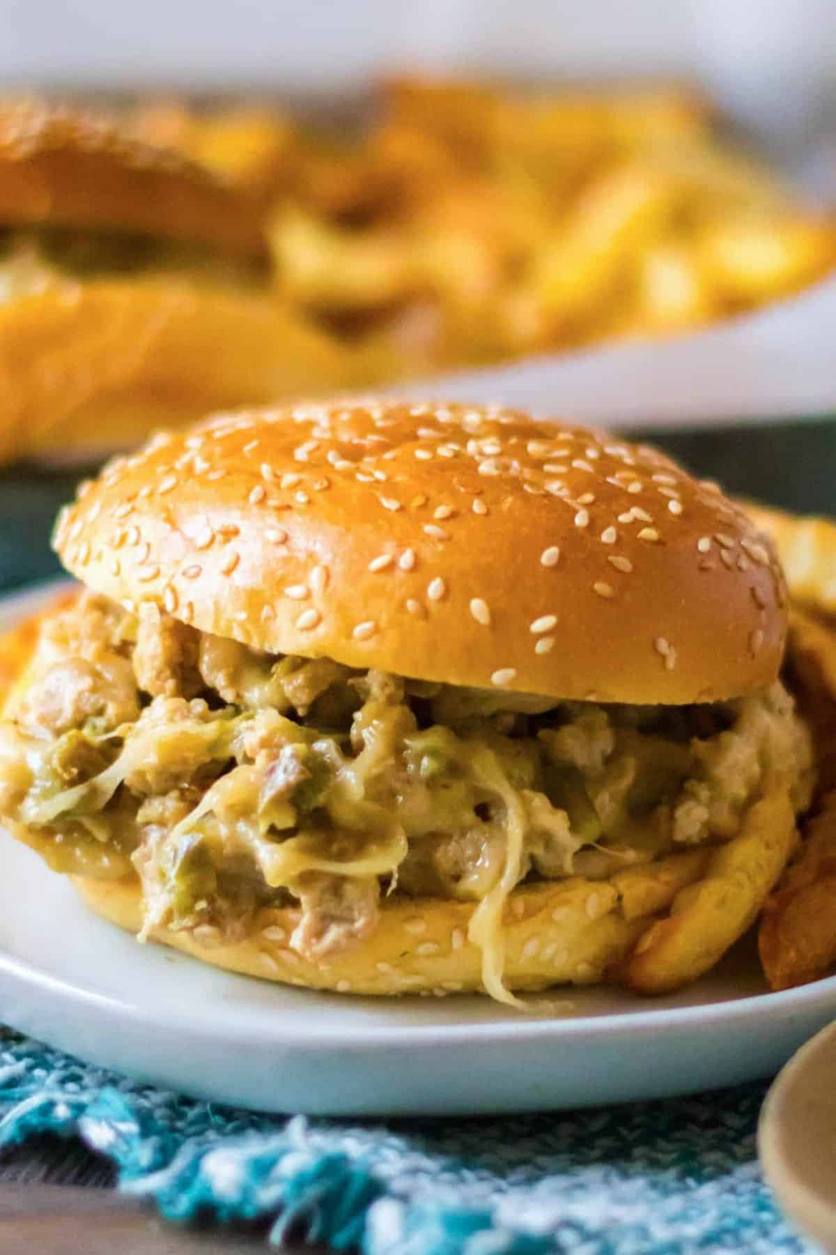Close-up of a burger stacked with a juicy patty, melted cheese, lettuce, and tomato in a toasted bun.