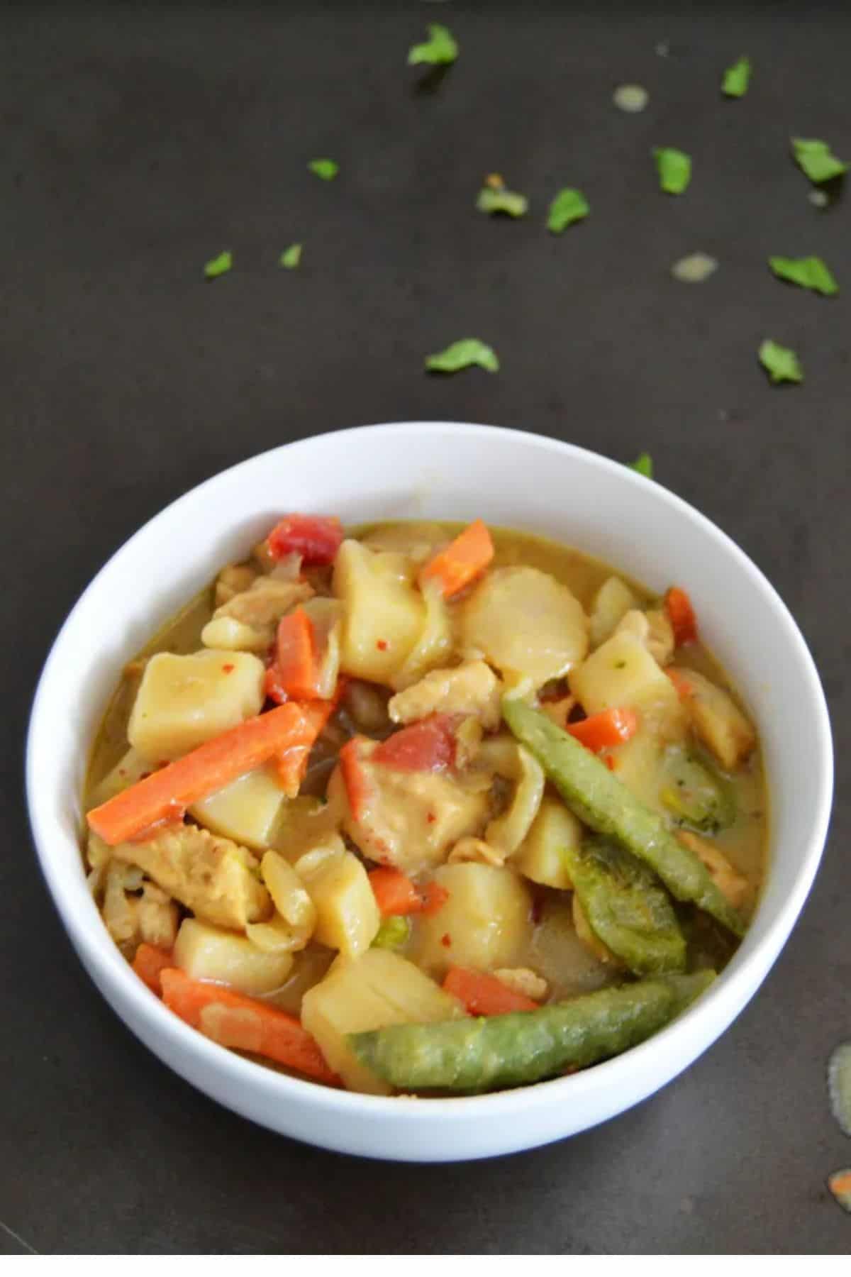 A bowl of soup filled with colorful vegetables and broth.