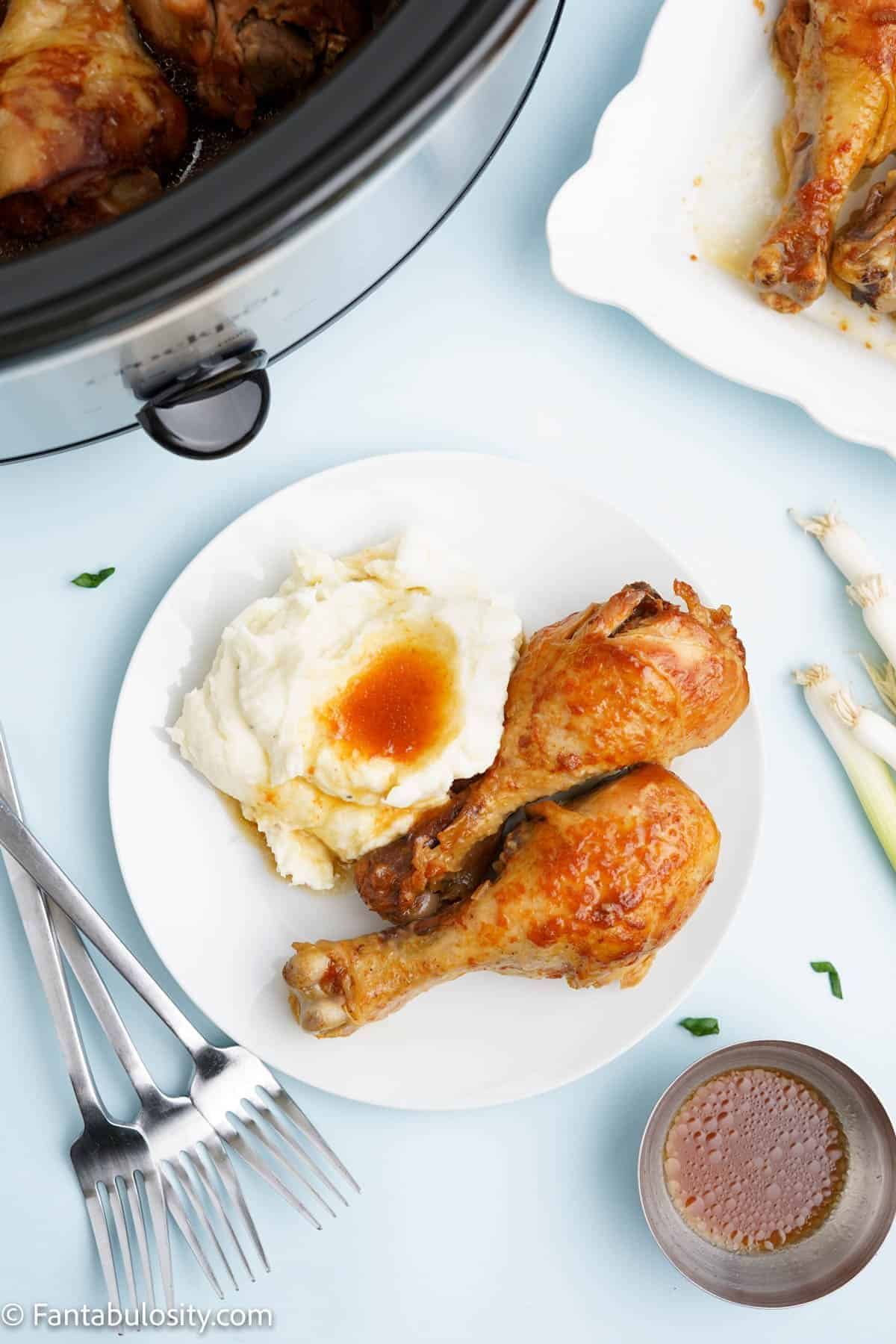 A plate with two pieces of drumstick and a sunny side up egg.