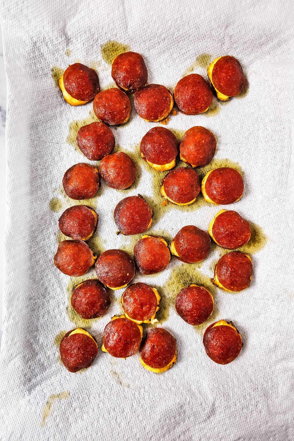 A baking pan with cream cheese pepperoni snacks stacked and arranged neatly, showing the golden baked pepperoni and creamy filling.