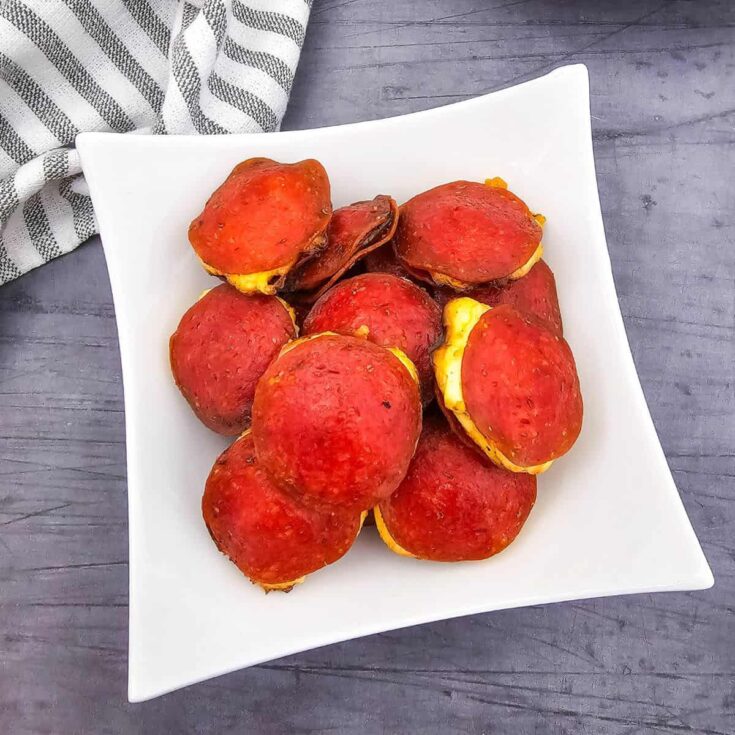 A plate stacked with cream cheese-filled pepperoni rounds.