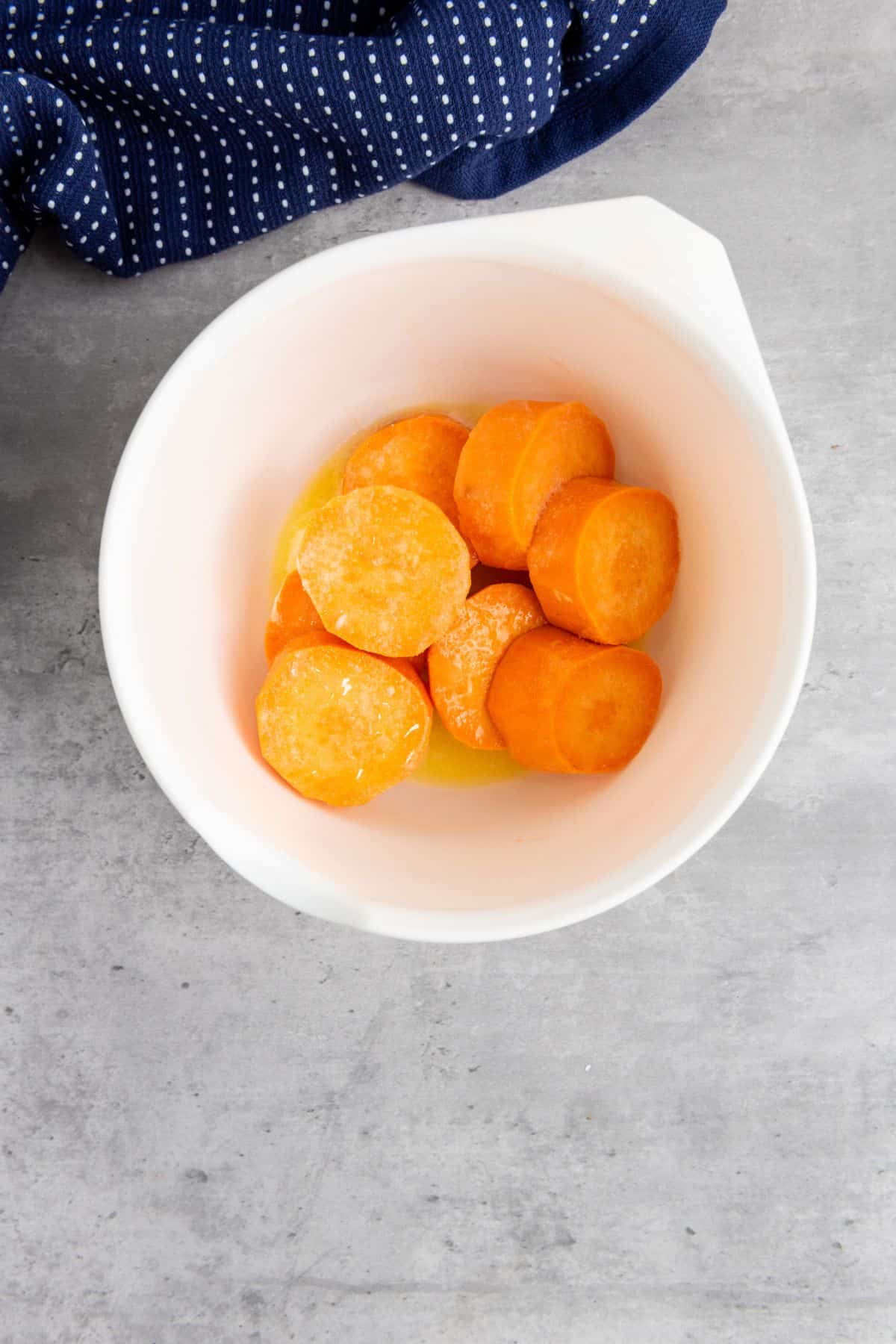 A bowl with sliced sweet potatoes.