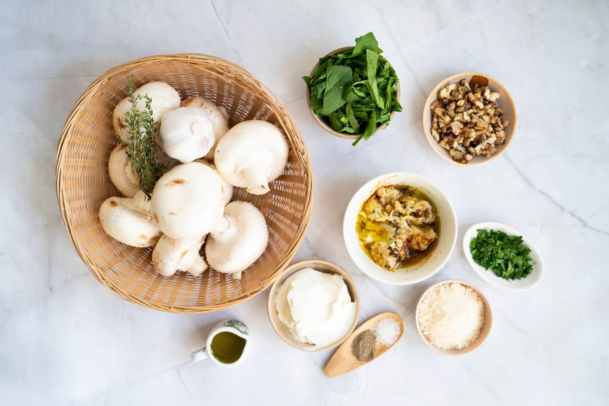 Ingredients of stuffed mushrooms with spinach marinated artichokes, arranged neatly in the surface.