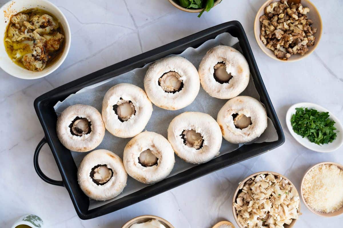 A serving dish with neatly arranged stuffed mushrooms.