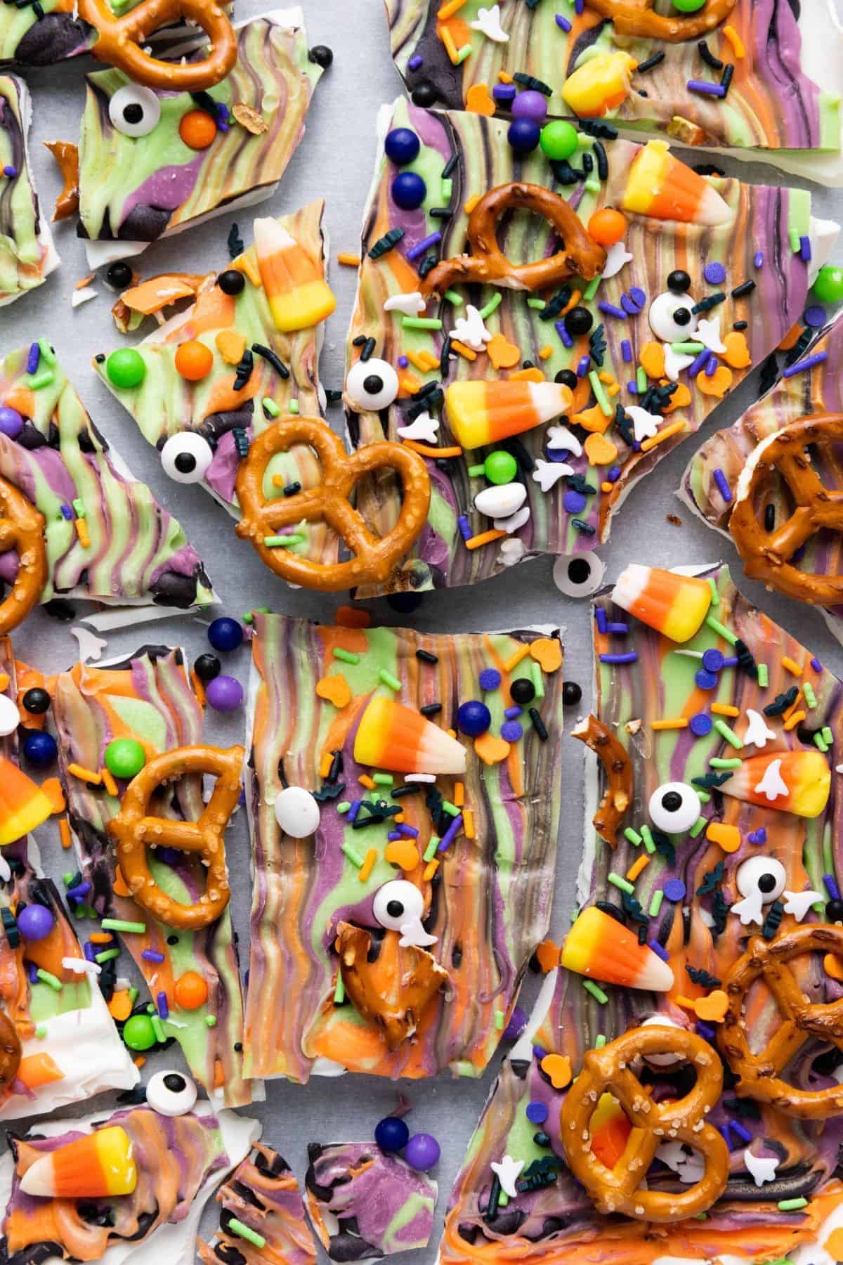 Cracked pieces of Colorful Halloween Candy Bark spread out on a flat surface.