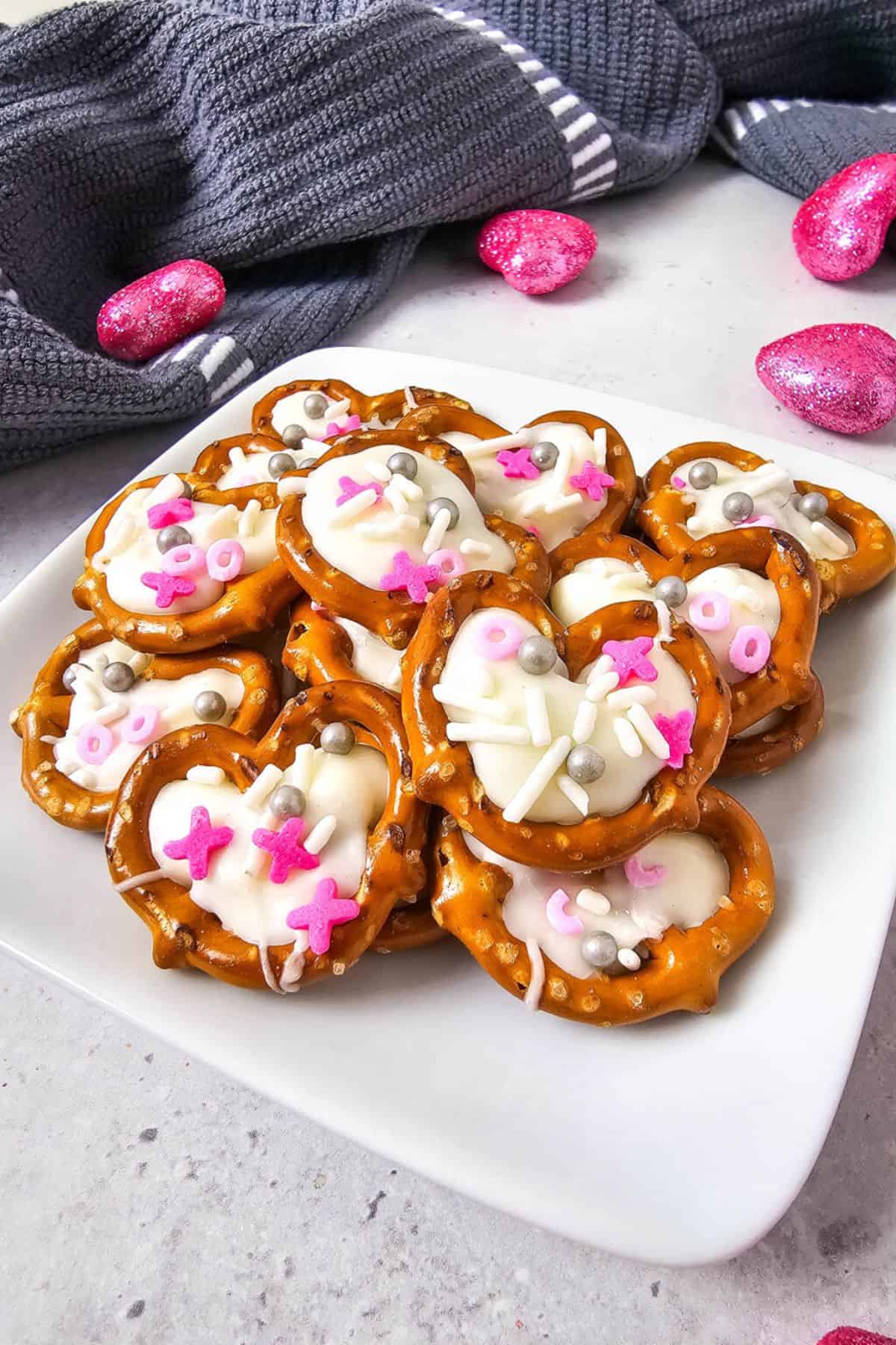 White chocolate pretzel hearts stacked on a plate, ready to serve.