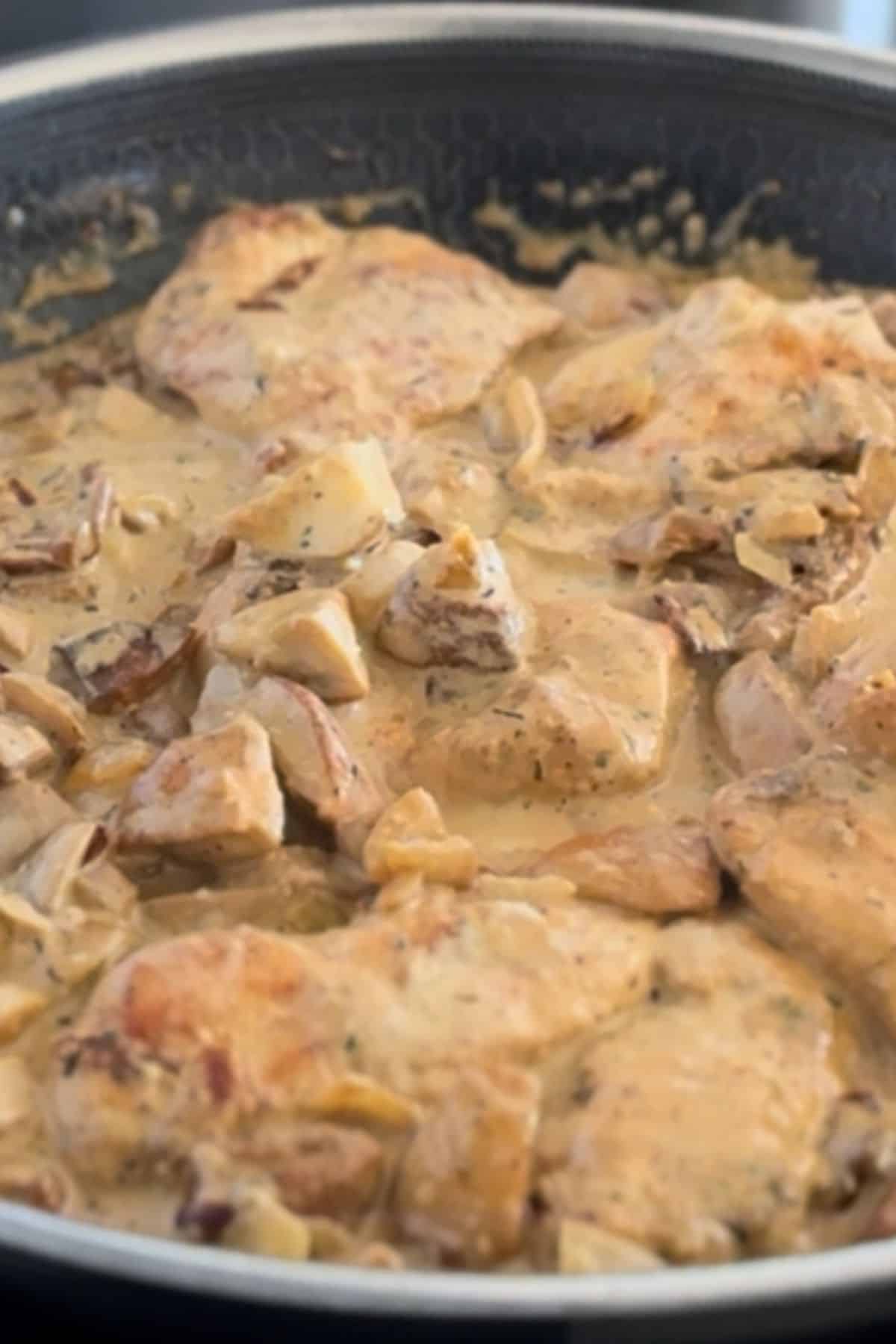 Close-up photo of creamy portini chicken in a medium pan.