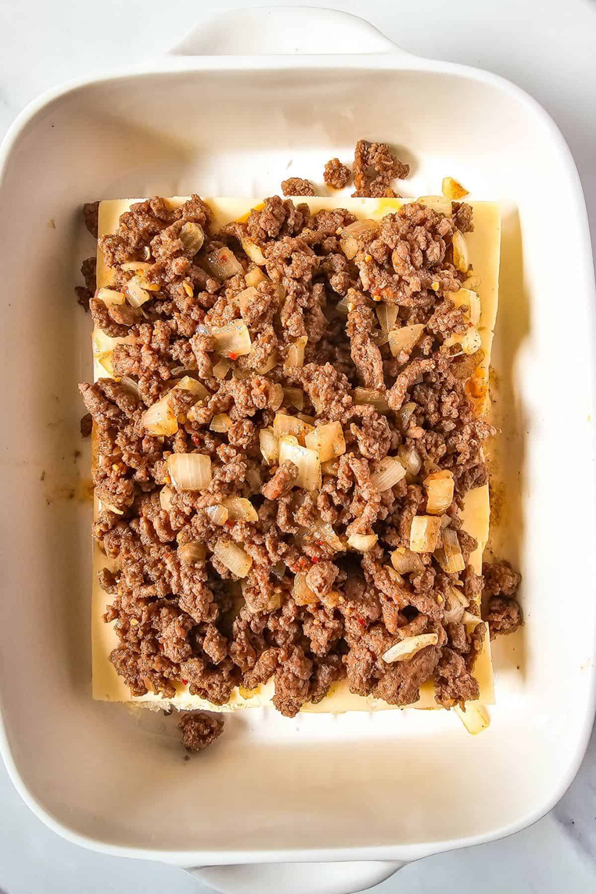 Cheese topped with ground beef on a slider half bun.