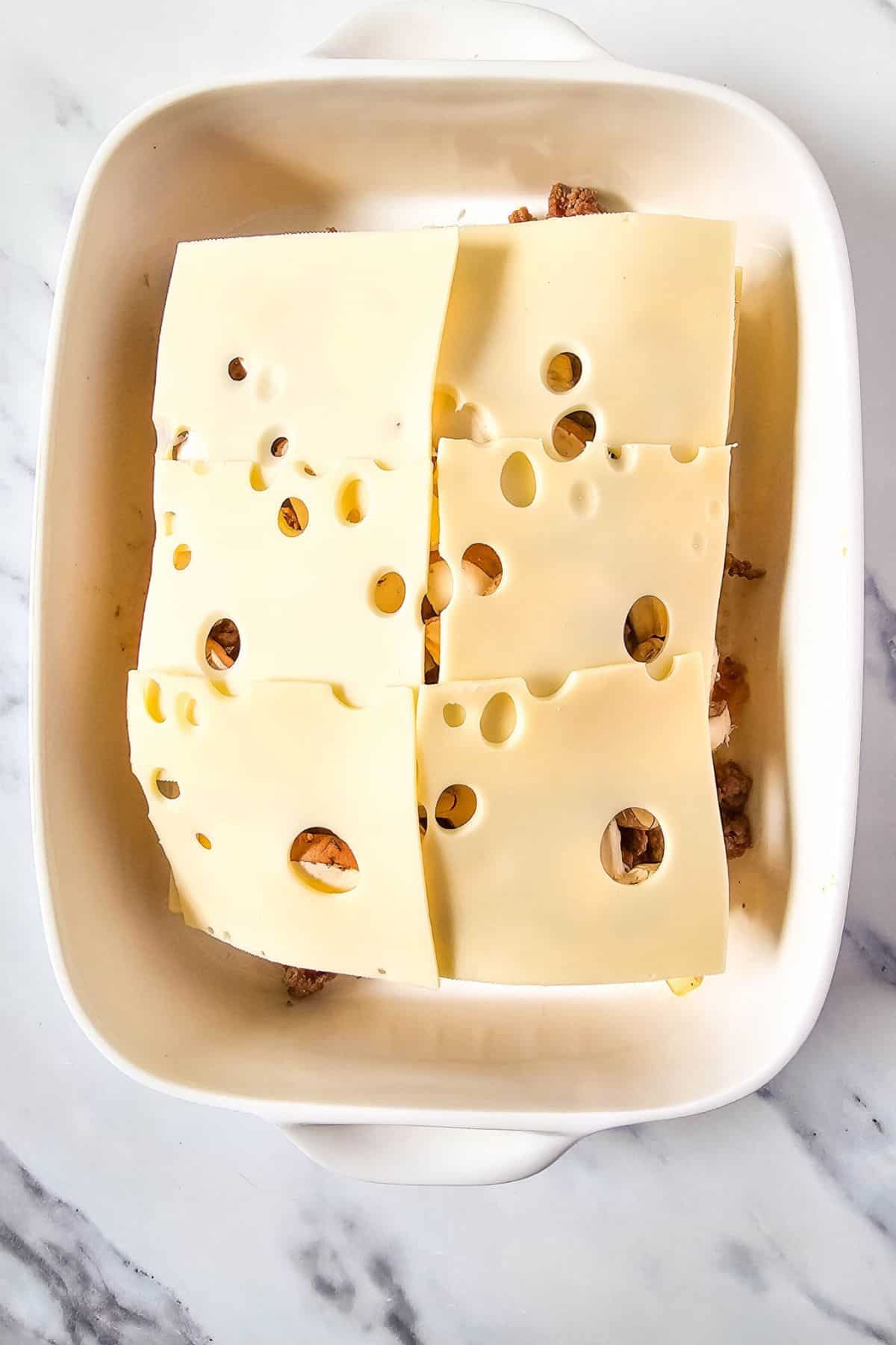 Cheese being placed on a slider half bun.