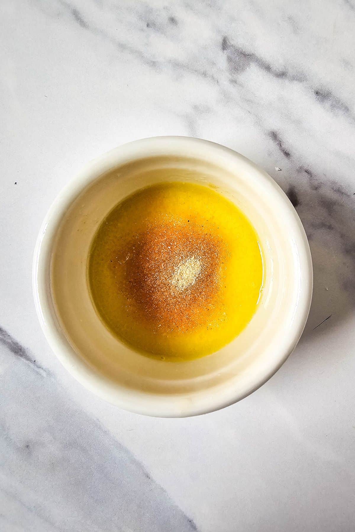 Melted butter mixed with seasoning in a small bowl.