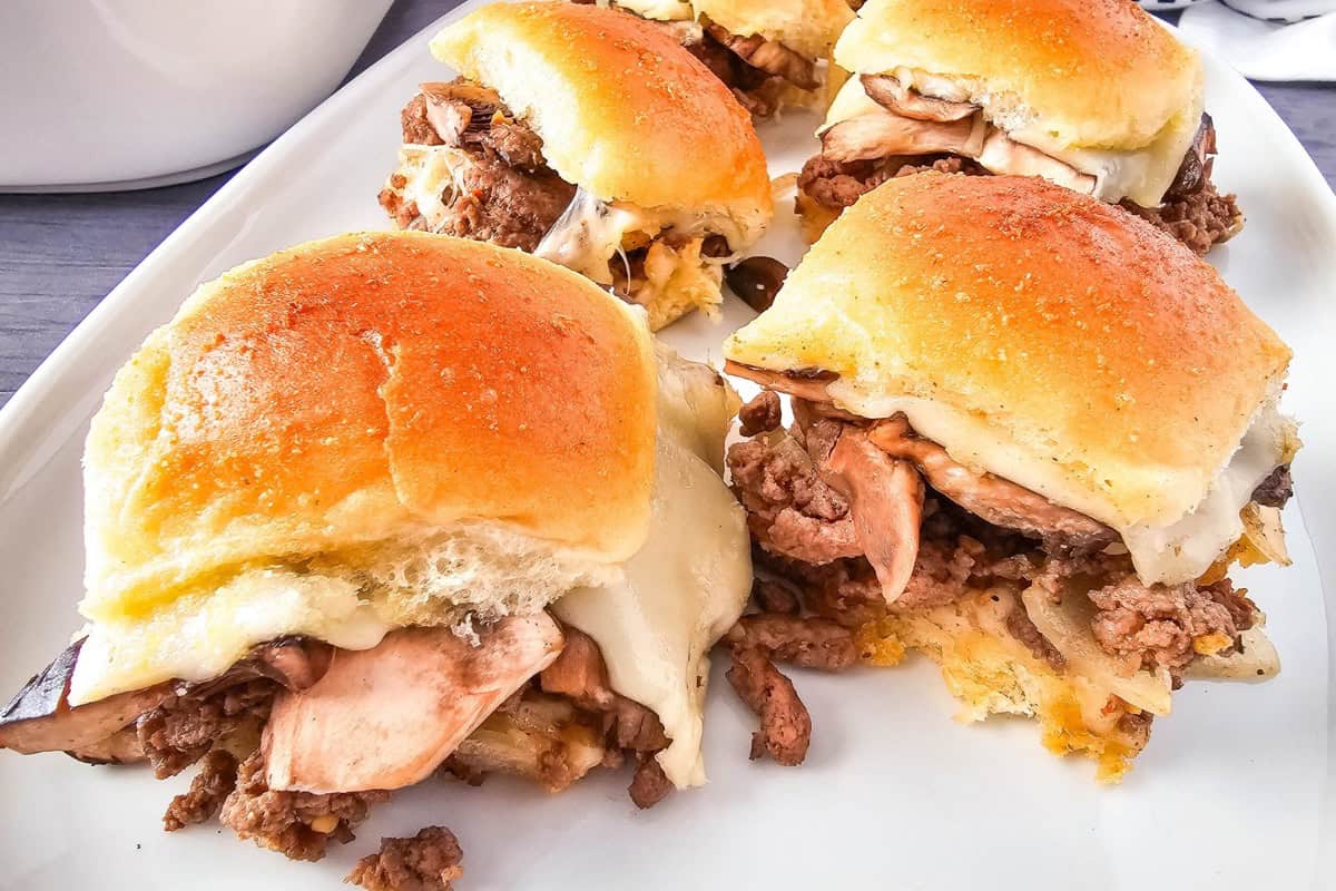 Close-up photo of sliders served on a plate with melted cheese.