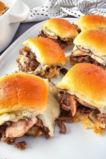 Sliders served on a plate with melted cheese.