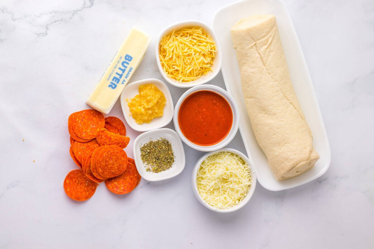 Ingredients for pizza puffs laid out on a table.
