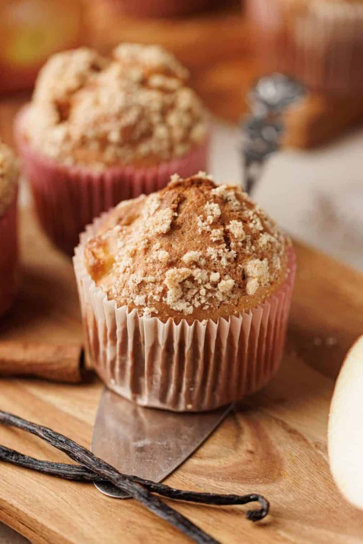 Close-up photo of apple cinnamon crumb muffins showing the crumbly topping and moist texture.
