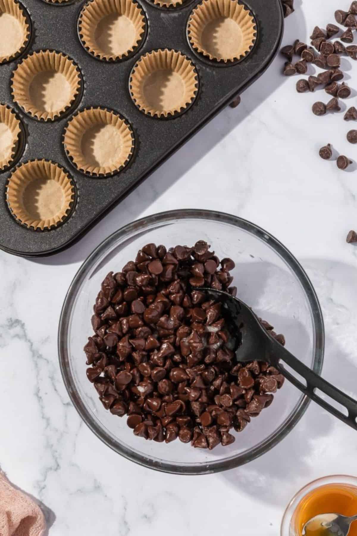 Chocolate kisses being placed into a medium-sized bowl, ready for melting.