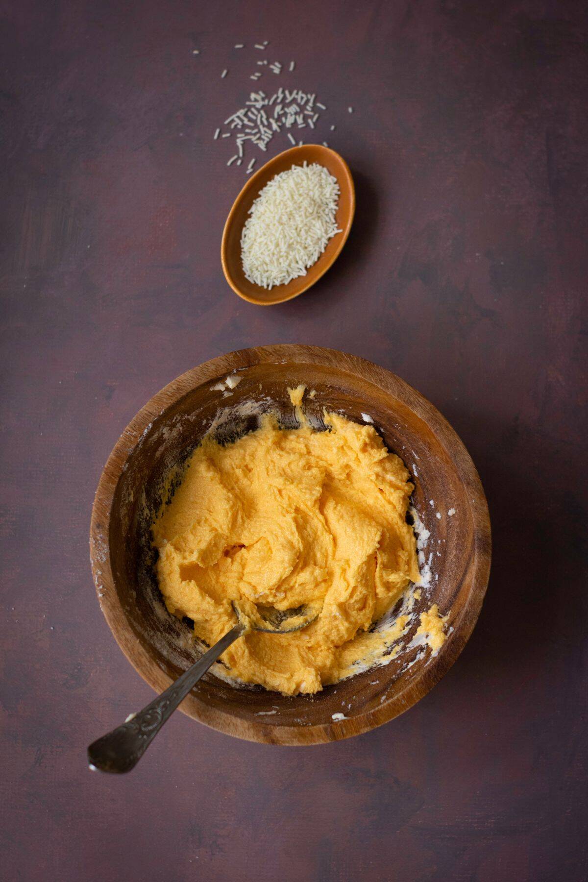 A rustic bowl holding a colorful cheesecake batter mixture.