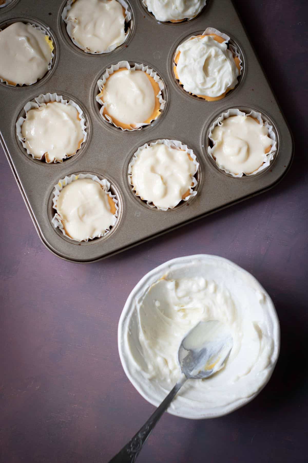 Tin can being filled with plain white cheesecake batter.