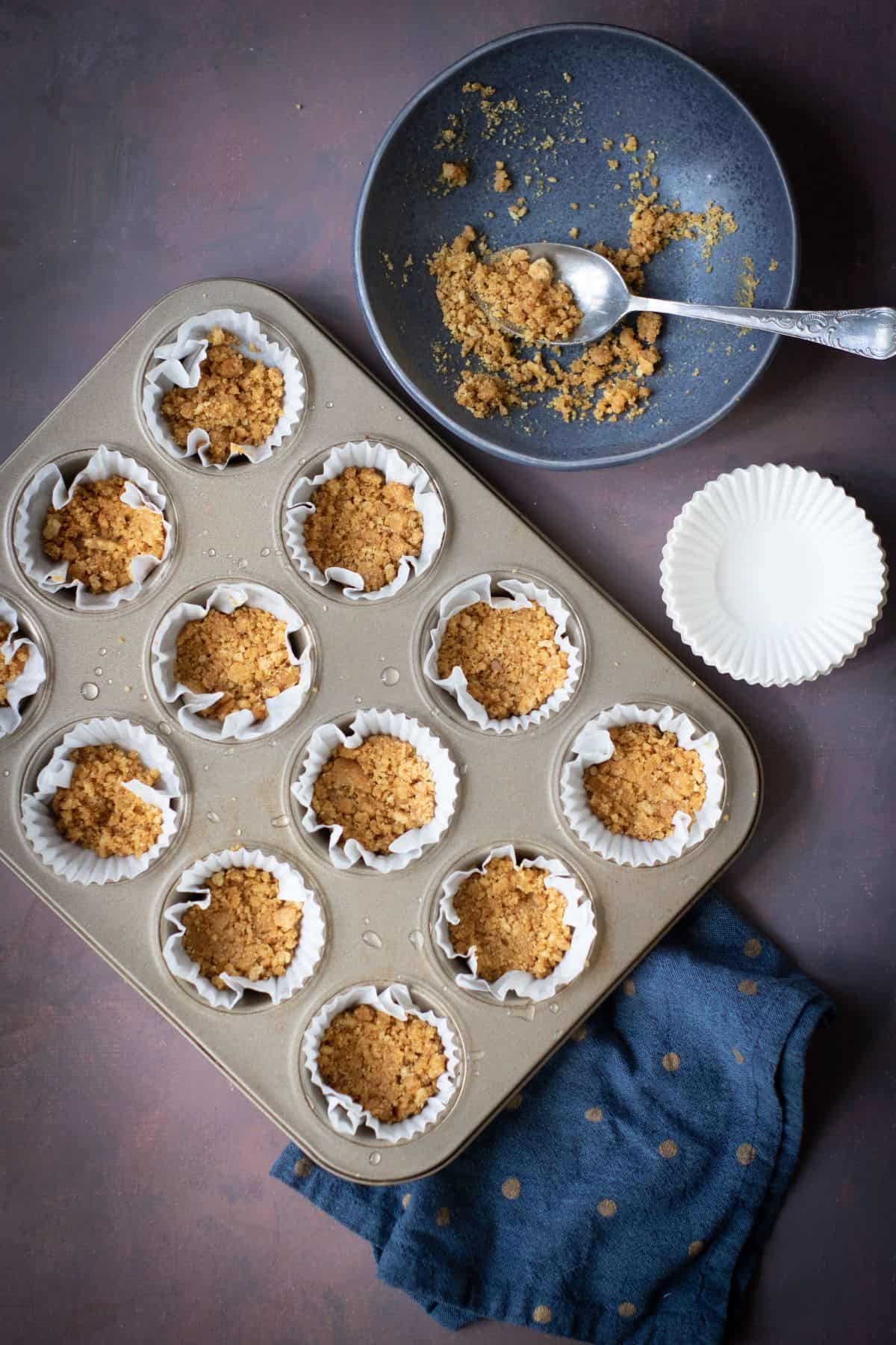 A tin can being filled with graham cracker crust mixture.