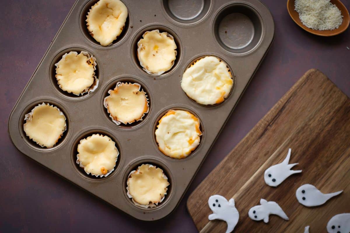 Tin cans each holding a muffin, with ghost toppers placed nearby.