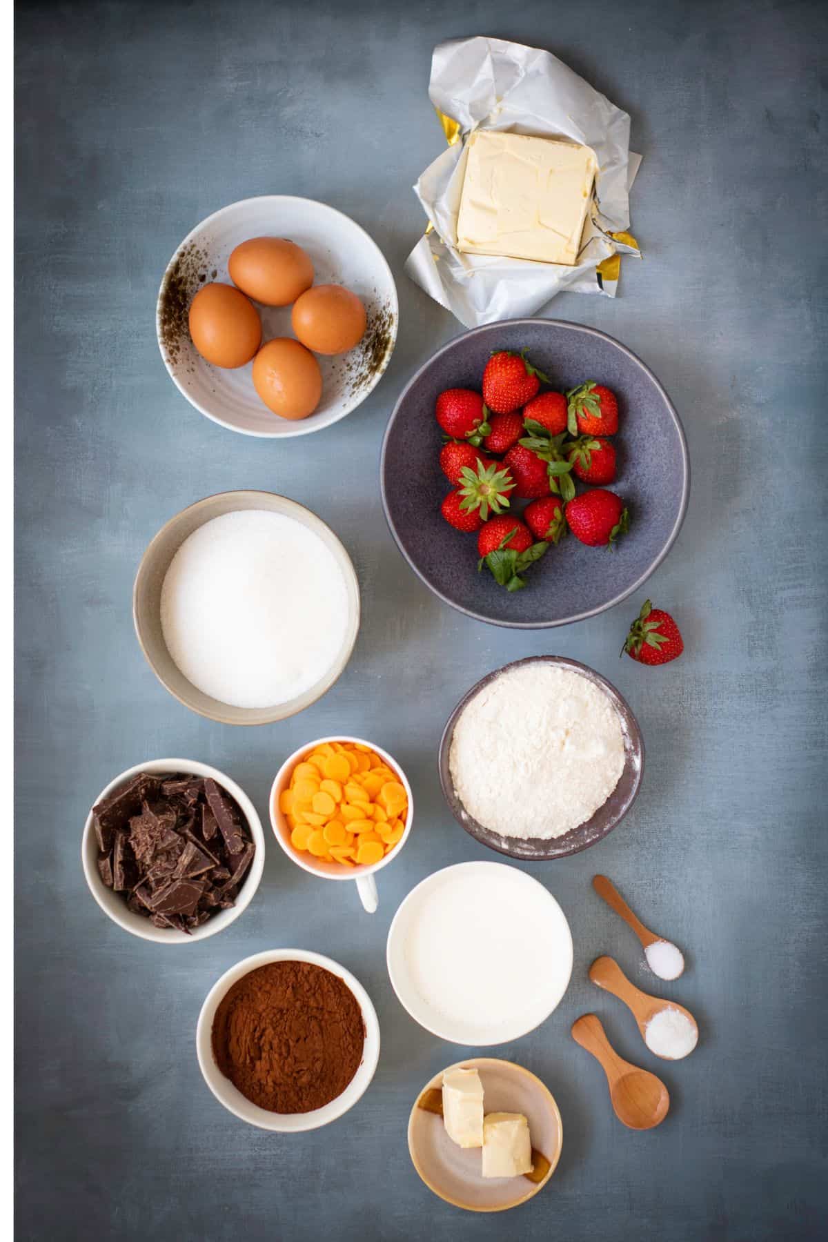 A baking ingredients neatly arranged on a flat surface, ready to be used for making chocolate brownies.