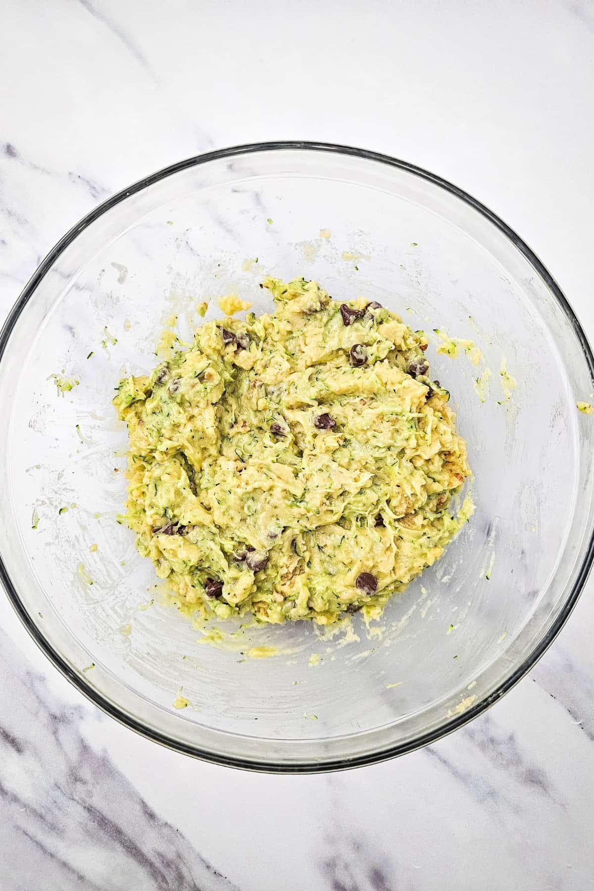 A bowl with mixture for chocolate chip zucchini bread.