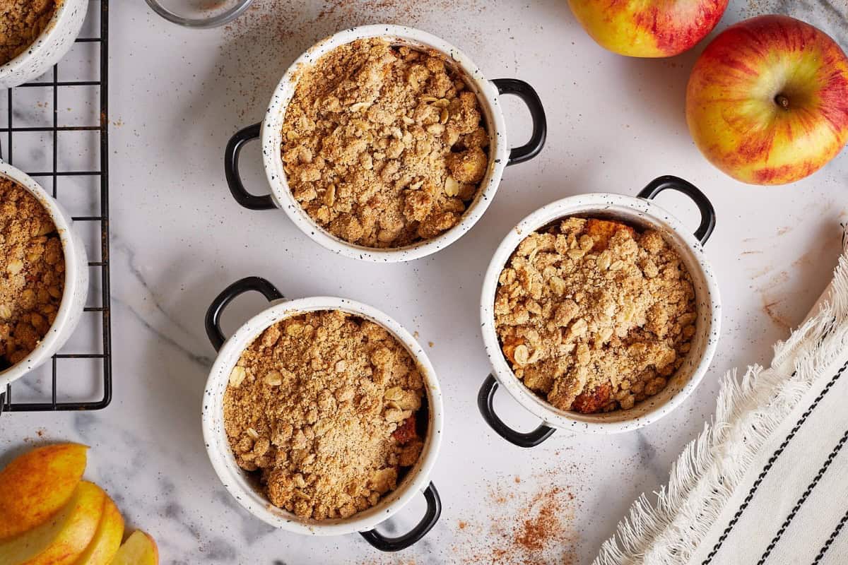A small bowl of mini apple crumble topped with a golden, crunchy oat topping.