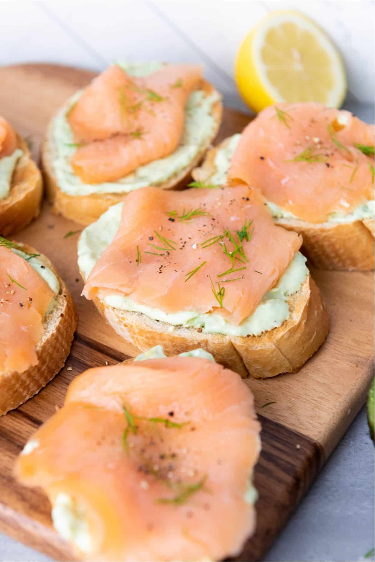 Close-up of smoked salmon served on a wooden board.