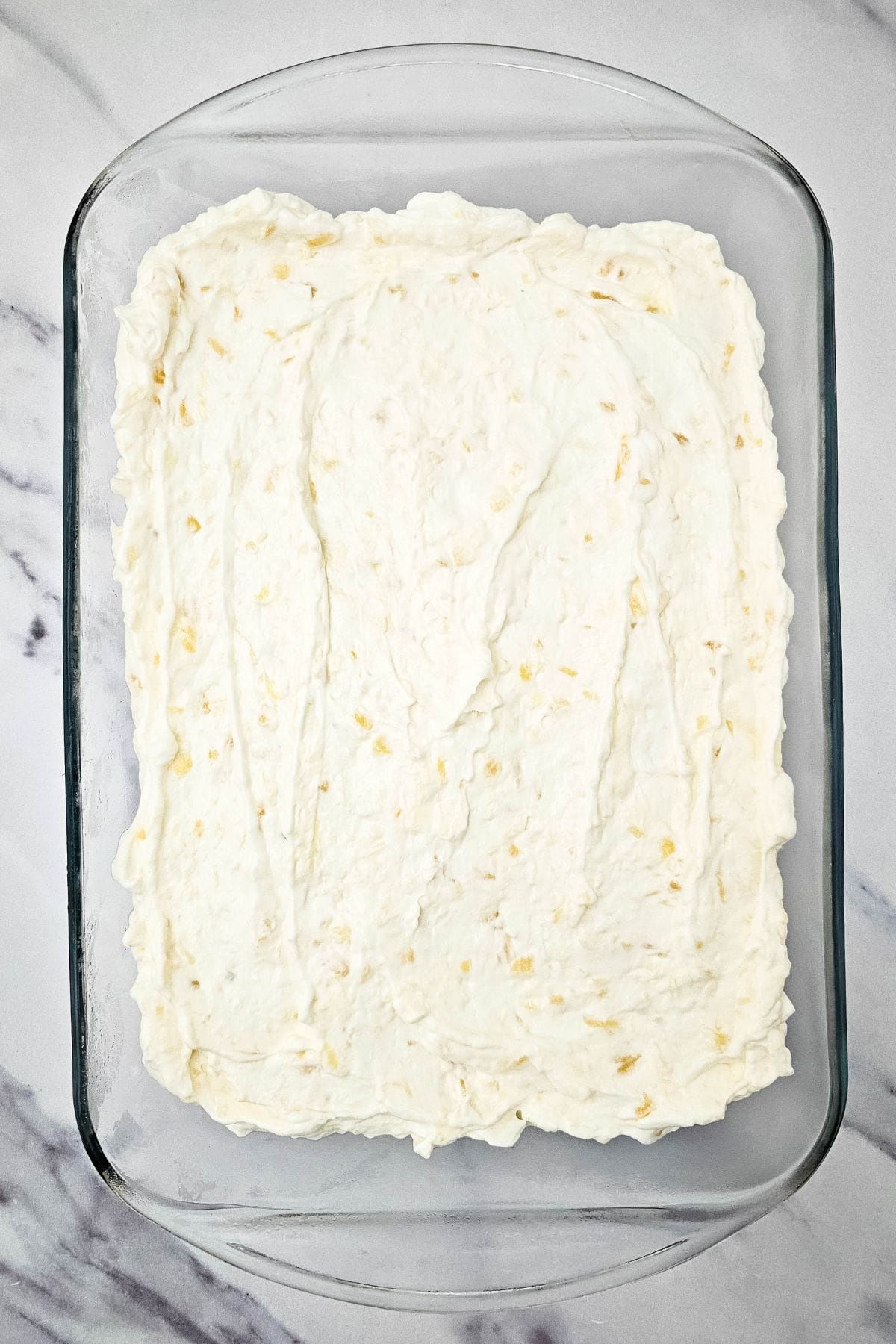 A serving dish filled with creamy pineapple dream dessert.