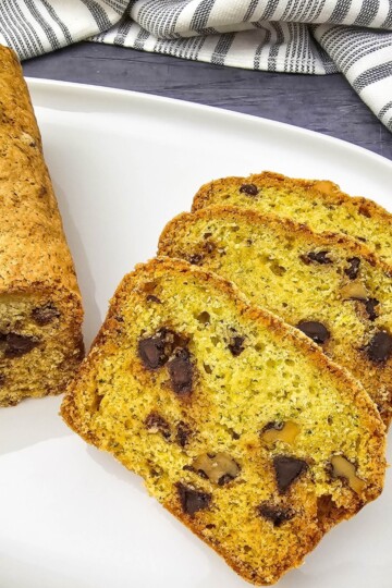 A loaf of bread with three slices on a plate.