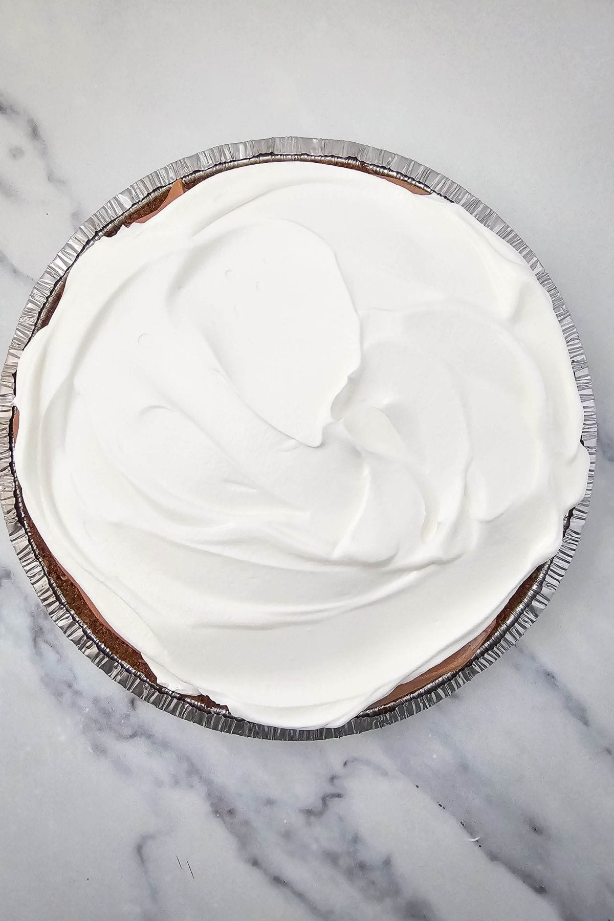 Chocolate pie with a chocolate crust, topped with whipped cream.
