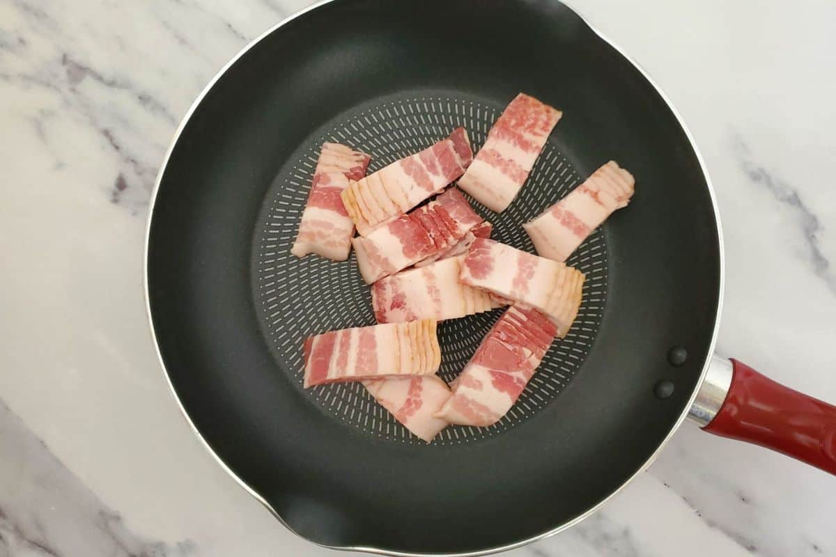 Chunks of pork simmering in a pot with seasonings.